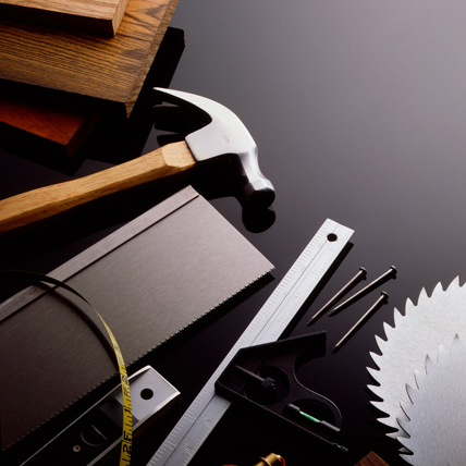 An assortment of hand tools on a grey background.